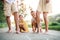 A midsection of young family with small children standing on a road in summer.