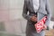 Midsection of young saleswoman holding sold placard and document in apartment