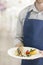 Midsection of young waiter serving lunch at restaurant