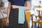 Midsection of young waitress with turquoise napkin at coffee shop