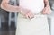 Midsection of young waitress tying apron while standing at restaurant