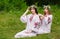 Midsummer. Two girls in the Slavic clothes weave braids in the hair near the fire