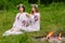 Midsummer. Two girls in the Slavic clothes weave braids in the hair near the fire