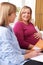 Midwife Discusses Leaflet With Pregnant Woman During Home Visit