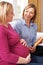 Midwife Discussing Literature With Pregnant Woman During Home Vi