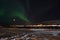 Mighty northern light dancing over snowy mountain peak in northern norway on the whale island