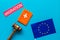 Migration to Europa concept. European flag near passport and judge hammer on blue background top-down copy space