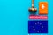 Migration to Europa concept. European flag near passport and judge hammer on blue background top-down pattern copy space