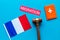 Migration to France concept. French flag near passport and judge hammer on blue background top-down copy space