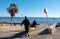 Mil palmeras, Spain - 11 January 2019: A group of men leisurely carrying a kayak into the ocean by the sea shore.