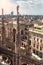 Milan Cathedral spires on background of cityscape, Milan, Italy. Scenery of luxury Gothic roof with statues. Milan skyline in