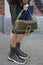 MILAN, ITALY - FEBRUARY 22, 2023: Man with brown and black Fendi logo shorts, bag and sneakers pattern before Fendi fashion show,