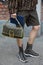 MILAN, ITALY - FEBRUARY 22, 2023: Man with brown and black Fendi logo shorts, bag and sneakers pattern before Fendi fashion show,