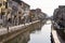 Milan, Italy - May 8, 2020: People walk in Naviglio Grande canal street wearing face mask. Police car keeps order. Second phase of