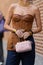 Milan, Italy - September, 21, 2022: woman wearing navy blue denim wide legs pants, pale pink fluffy handbag, camel