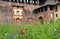 Milan Sforza Castle medieval tower, fortifications, flowering internal garden and ancient brick wall background.