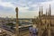 Milan skyline spires and statue of Duomo di Milano rooftop Italy