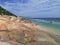 Mild colors of the pink limestone and azure waves on the distant beach