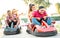 Milenial friends having fun at children playground on go kart race - Young people with face mask competing on mini car racing