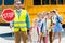 miling traffic guard with scholars looking at camera in front of