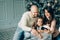 Miling young family in Christmas atmosphere making photo with smartphone