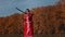 Militant concept - feisty blonde woman in red national dress training her swordplay