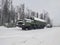 Military all terrain truck with a metal frame and box body in the ranks of military equipment in winter against the background of
