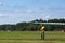 Military armed man wearing camouflage look at take off plane SAAB 105 Sk 60 on airshow at Ronneby flygdag F-17