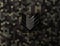 Military black glossy sergeant rank sign on hex pixel camouflage background. Modern army camouflage hexagon pixel texture.