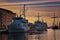 Military boats in the harbor of Wismar with sunset over the Baltic Sea in the background