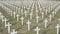Military cemetery with white crosses. Headstones in War memorial. Numerous soldier`s graves marked with Christian crosses. The fa