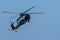 Military chopper shooting machine guns in combat and war flying into the smoke and chaos and destruction. Military concept of