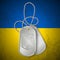 Military dog tag with national symbols of Ukraine on dirty flag. Ukraine conflict.