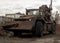 Military engineering earthmoving machine on wheels with trenching bucket