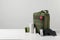 Military first aid kit, tourniquet, drops and elastic bandage on white table, space for text