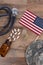 Military Health Care Concept. Dog tags, stethoscope, pills, camouflage hat and American Flag on a wood background
