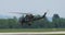 Military Helicopter in Dark Green Camouflaged Takeoff and Low Altitude Flight