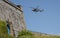 Military helicopter landing at garrison fortress, Plymouth, UK