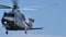 Military helicopter in stationary flight in the blue sky of a sunny day