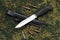 Military knife blade down on black leather sheath