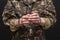 A military man in handcuffs holds an army badge in his hand on a dark background, selective focus. Concept: war criminal, prisoner