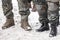 Military men in special uniform and boot stood outside in winter