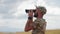 Military Observing Through Binoculars, Man in camo using binoculars in an open field examines the enemy's