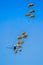 Military parachutist paratroopers parachute jumping out of a air force planes on a clear blue sky day