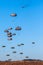 Military parachutist paratroopers parachute jumping out of a air force planes on a clear blue sky day