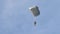 A military paratrooper falls on a parachute.