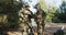 The military prepares for a field exercise, men dressed in moro uniforms with rifles slung over their shoulders, helmets