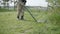 Military sapper with a metal detector in the field