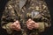 A military soldier or officer in handcuffs holds bundles of dollar bills in his hands, selective focus, dark background. War crimi