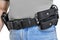 Military tactical belt with semi-automatic buckle for connection with cartridge pouch, placed on man`s belt, isolated - front view